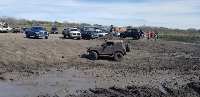 Jeep offroading in muddy field with crowd at 281 Country Club TX