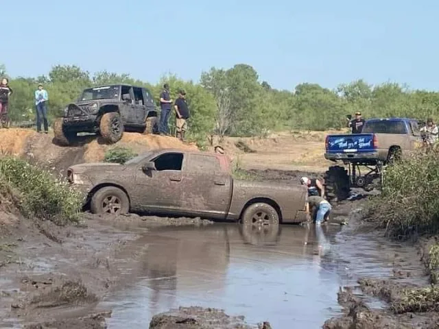 Ram truck in mud with Jeep on hill and crowd watching at 281 CC