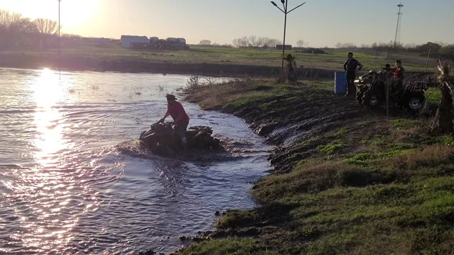 ATV entering flooded water crossing at sunset at 281 Country Club